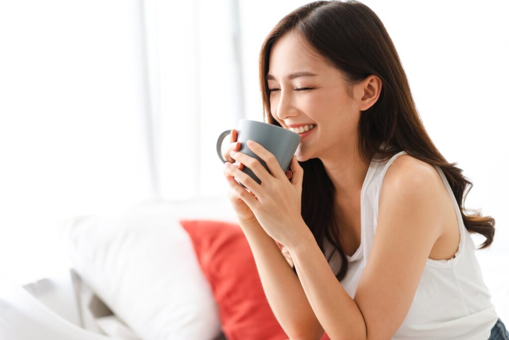 A woman is enjoying a cup of coffee full of smile